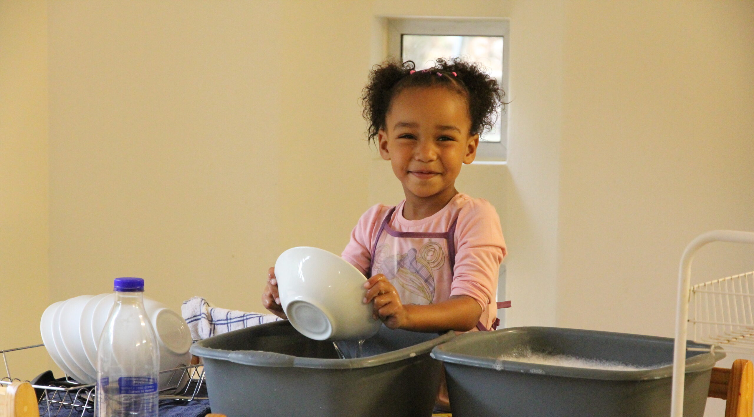 Follow the child: Early Childhood Development inspired by the Montessori way. A task such as washing dishes builds independence and confidence.